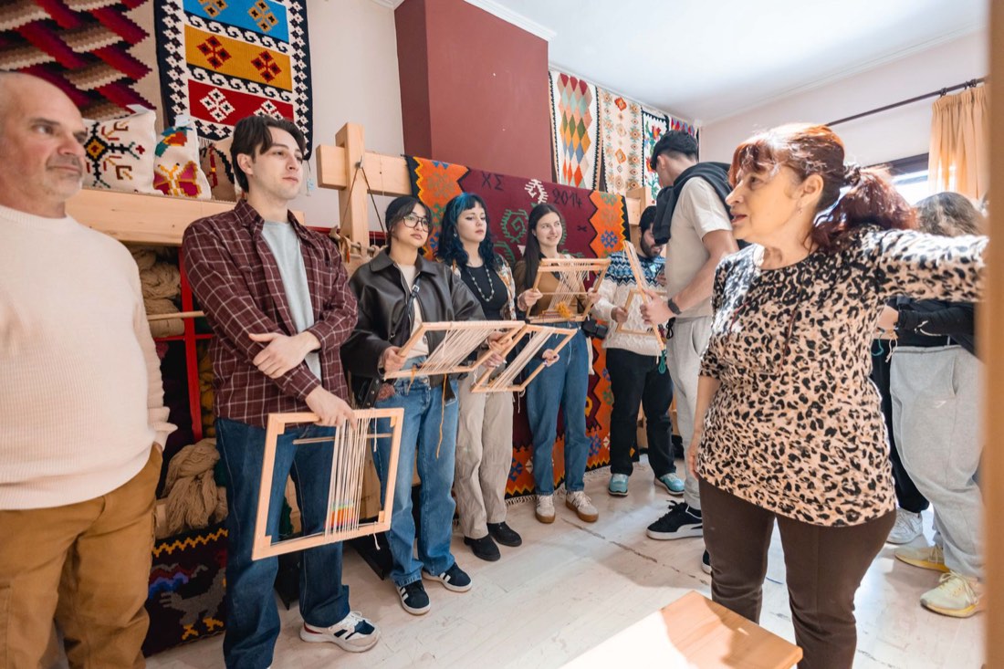 The group listening to the weaving teacher