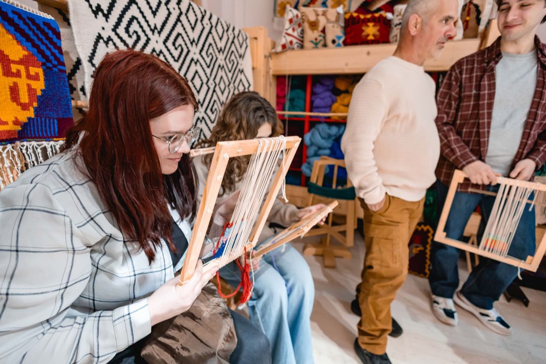 Participants trying out warp threads on their looms