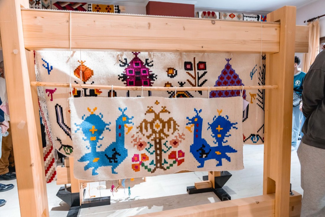 Traditional woven textile with peacock motifs on the loom