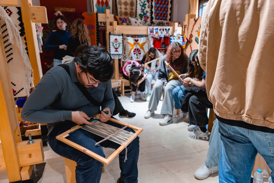 Participants weaving on small frame looms